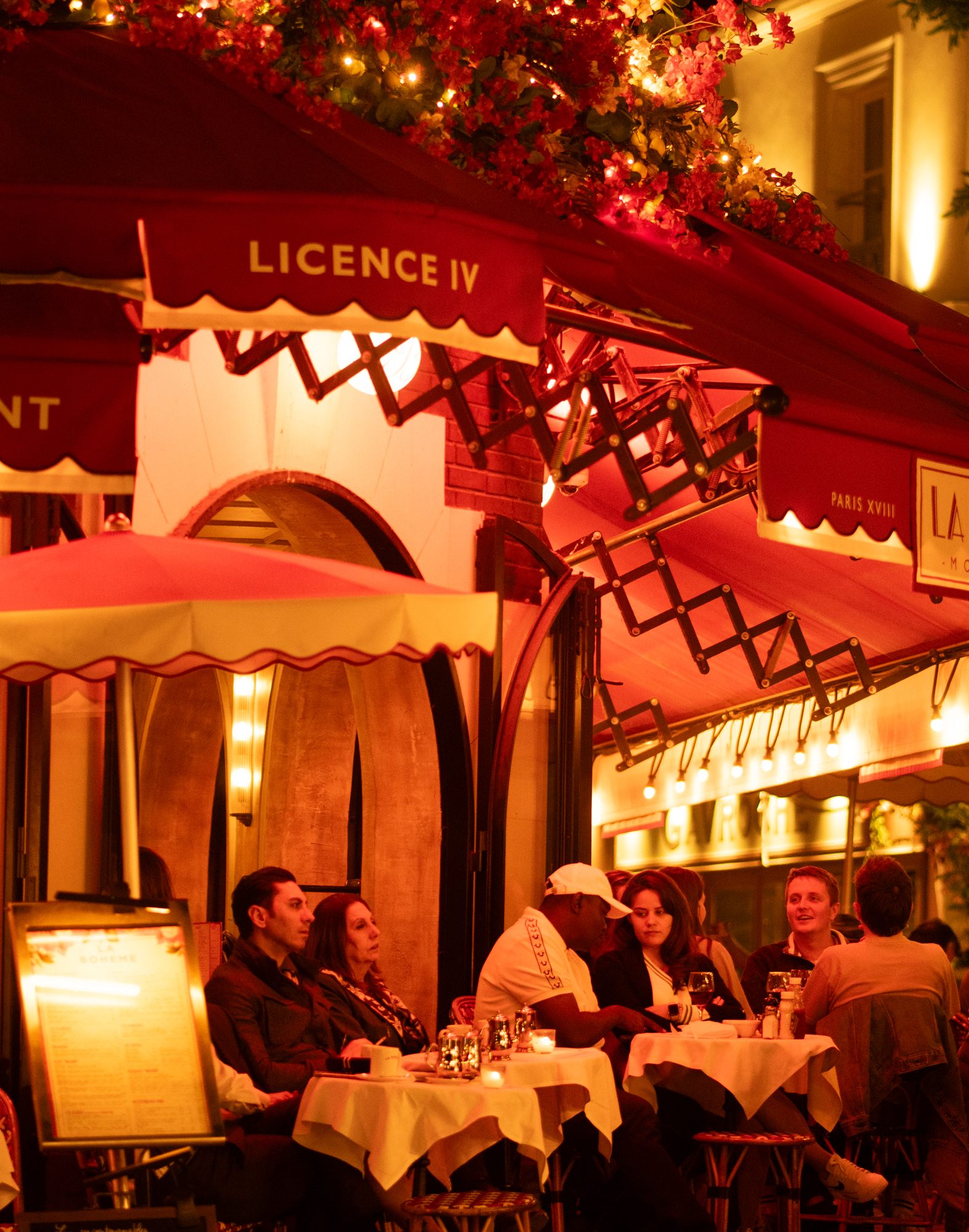 Parisian café with a red awning at night